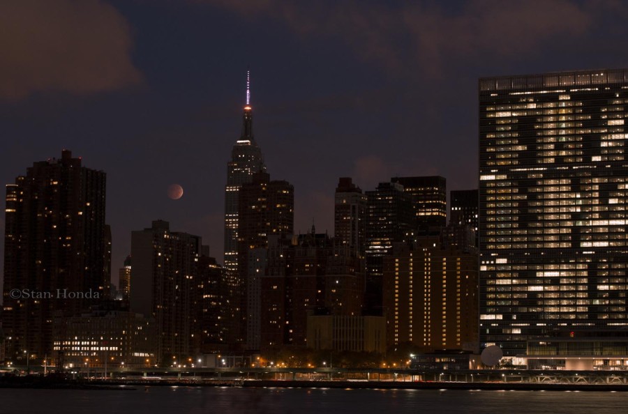 Total lunar eclipse as moon sets behind Manhattan skyline.