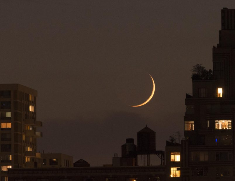A crescent moon sets on the west side of Manhattan, June 6, 2016.