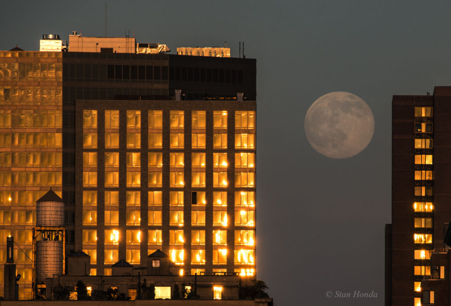 A nearly full moon rises between apartments on the east side of Manhattan, June 19, 2016.